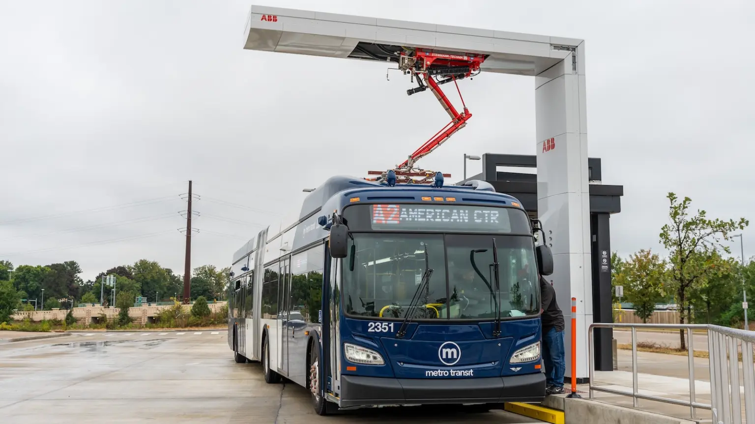 A Metro Transit bus parked beneath a pantograph “quick charger”