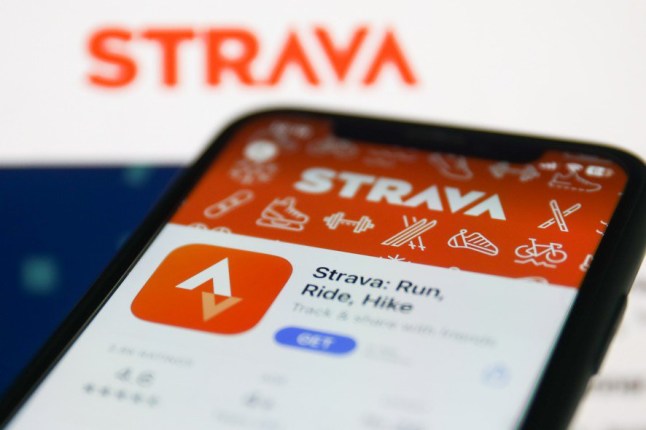 Strava on App Store displayed on a phone screen and Strava website displayed on a screen in the background are seen in this illustration photo taken in Krakow, Poland on January 19, 2023.