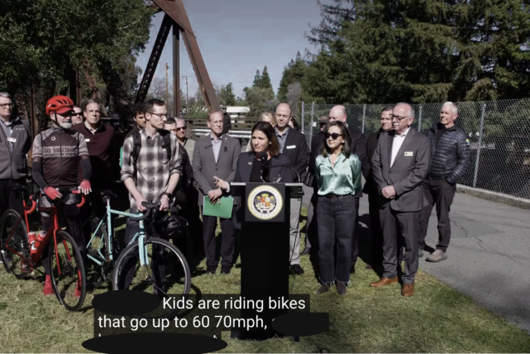 A man wears a derby hat and glasses