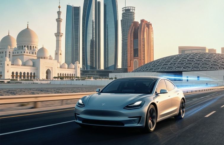 A silver Tesla saloon car travels along an Abu Dhabi road with digital blue light trails, with the Sheikh Zayed Grand Mosque, Etihad Towers and the Louvre Abu Dhabi visible in the background at dusk
