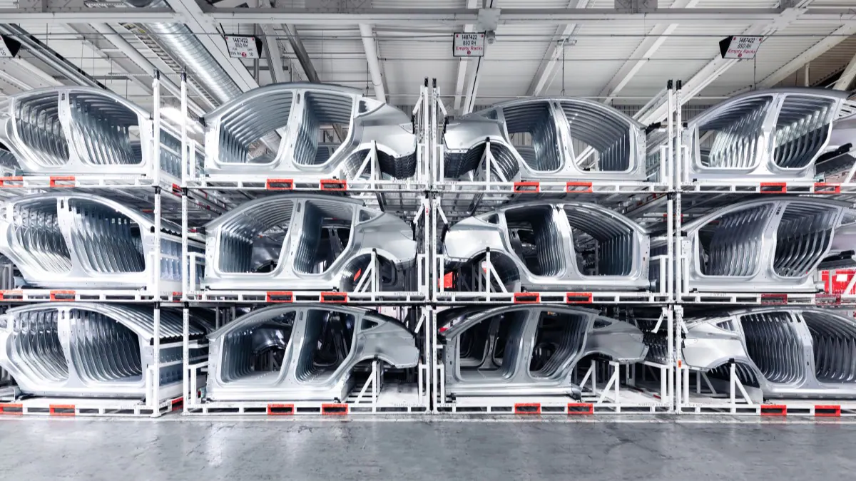 Tesla Model Y bodies-in-white stacked awaiting assembly