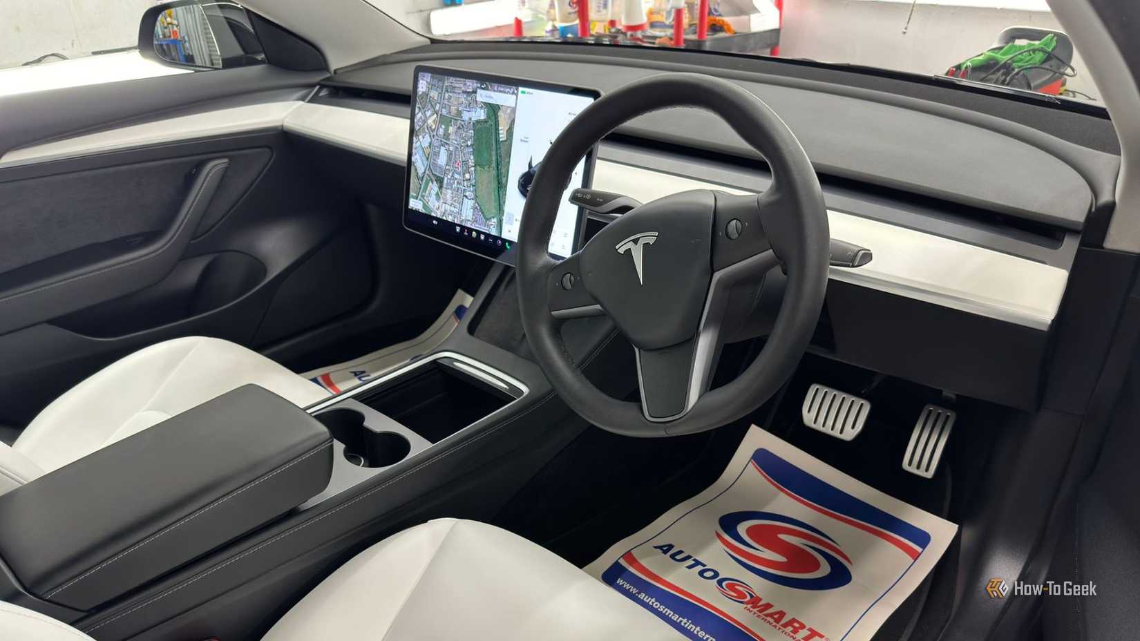 Shot inside the cabin of a 2021 Tesla Model 3 Performance, showing the white interior and infotainment screen.