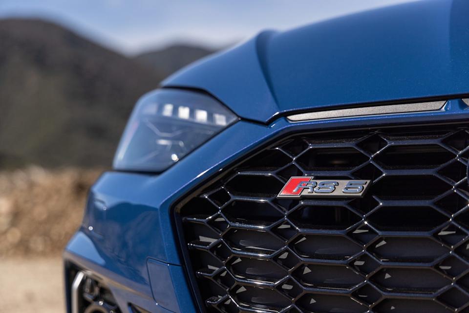 closeup of a blue cars grille featuring rs 8 emblem