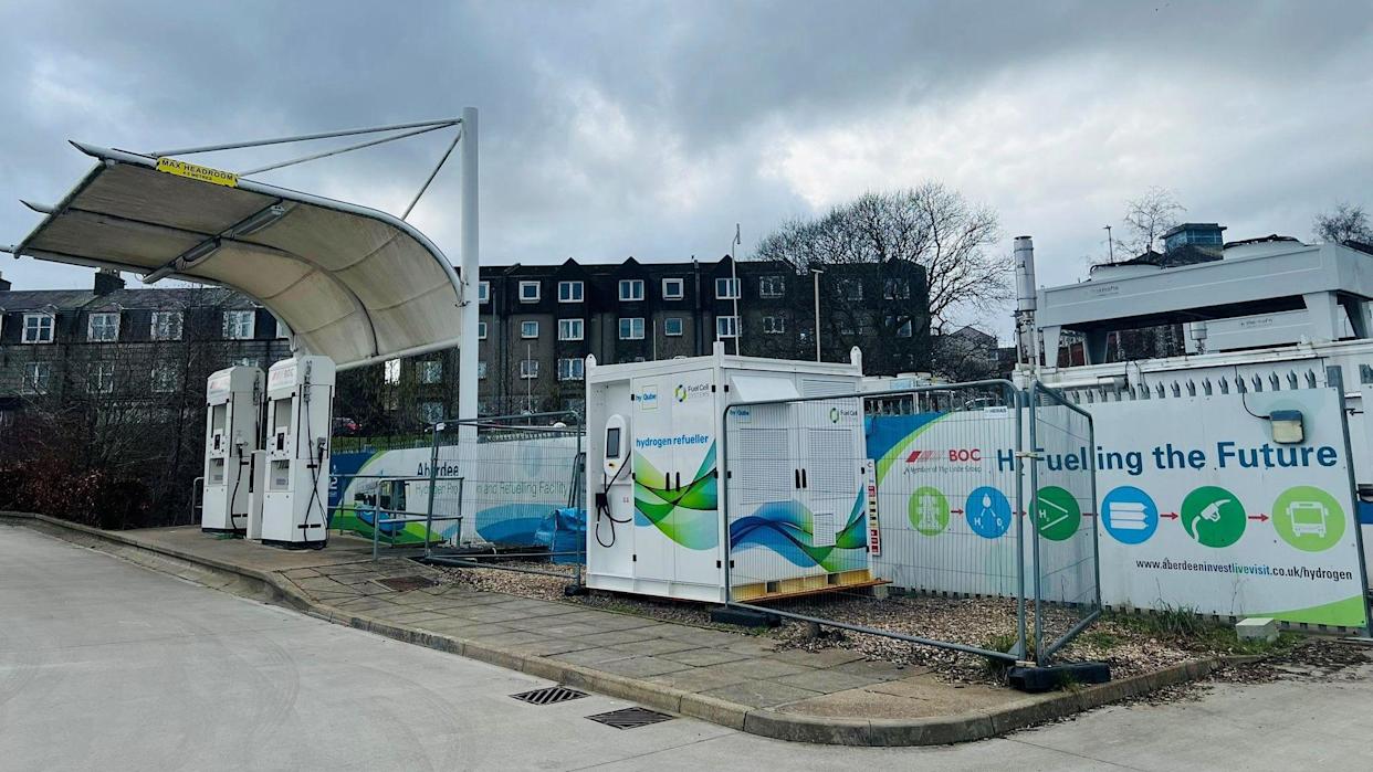 A hydrogen fuelling station, with rows of flats in the background.