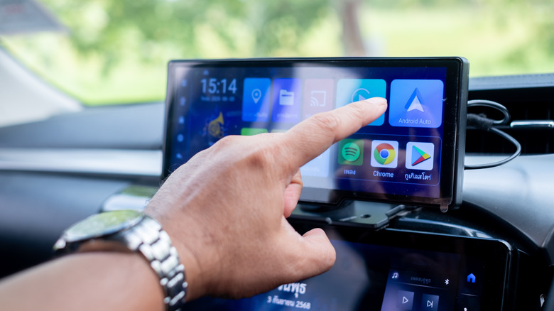 Someone getting ready to press the Android Auto shortcut on car display.