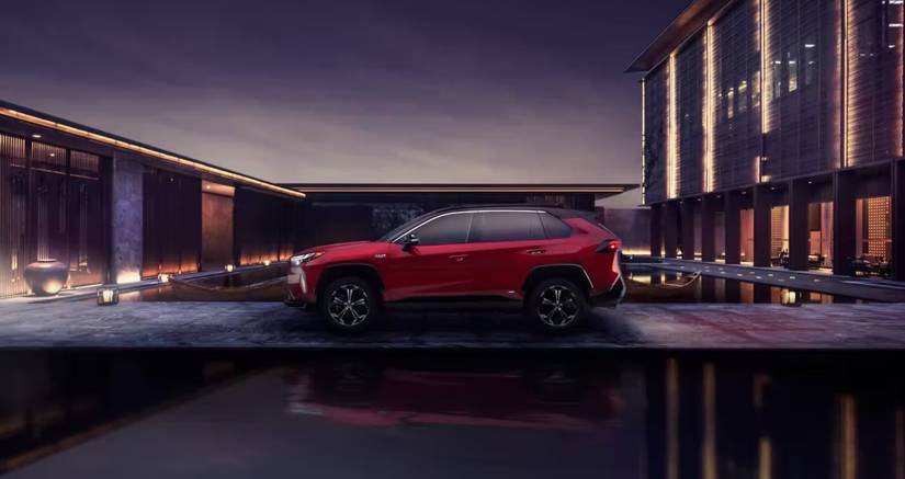 Rav4 Prime red side view modern building
