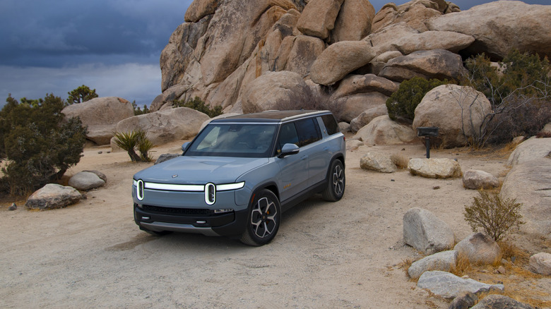 A Rivian R1S is parked at the Ryan Campground as dark storm clouds gather overhead, signaling a rare snowstorm expected later that night