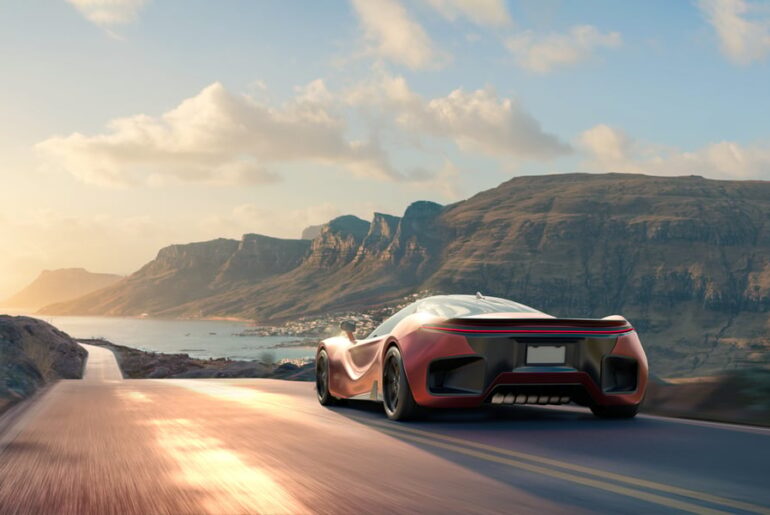 Sports car driving on road near mountains.