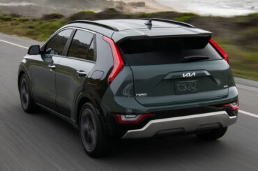 Rear 3/4 view of Kia Niro Hybrid on road by the seaside