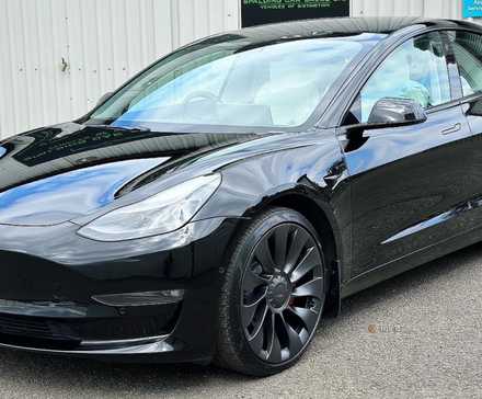 Static front 3/4 shot of a black 2021 Tesla Model 3 Performance.
