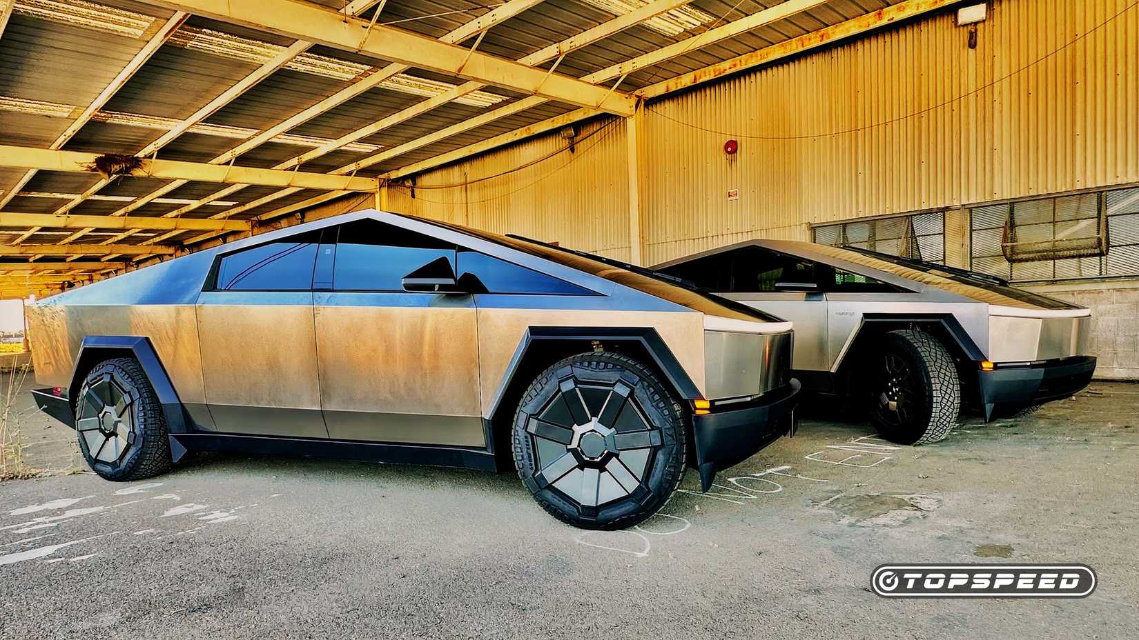 A Passenger Side Shot Of Two Tesla Cybertrucks Parked 