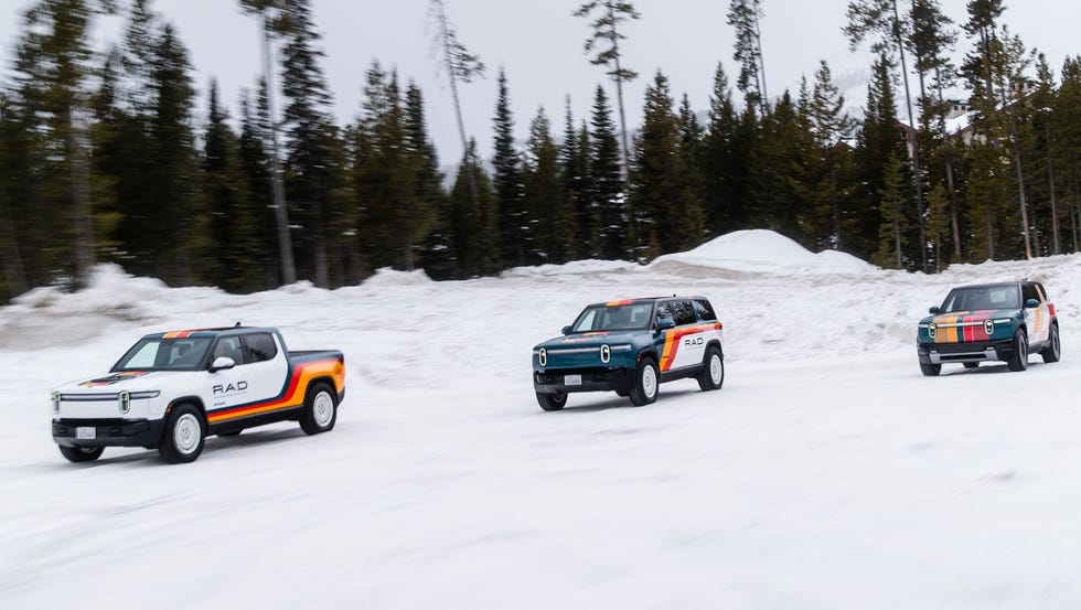 Rivian RAD three electric vehicles driving on a snowy surface in a forested area