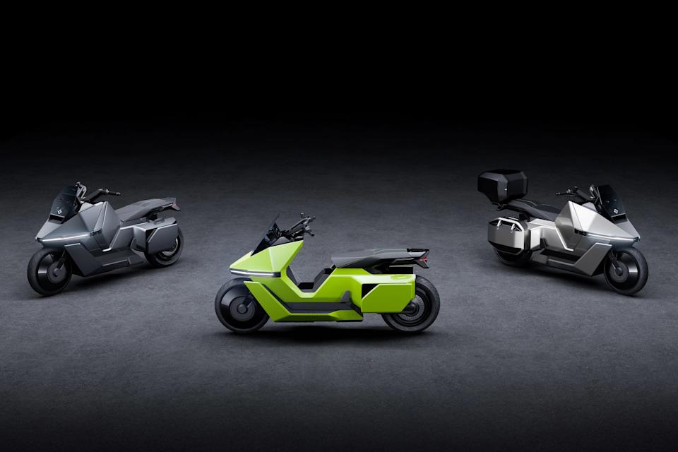 Three futuristic motorcycles in a row on a dark floor, with two silver models on the sides and a lime green model in the center.