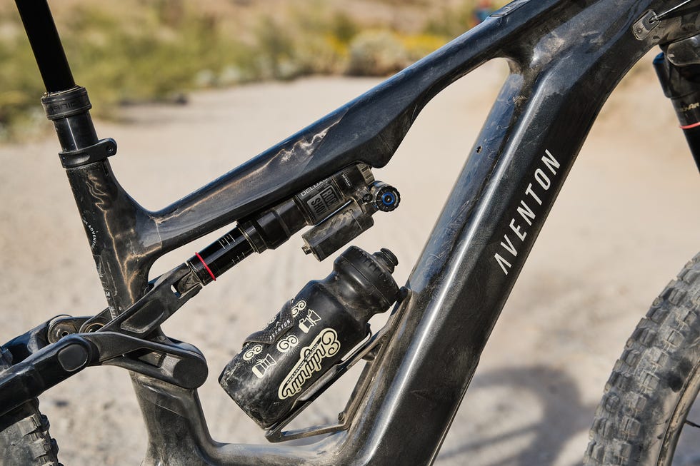 Mountain bike frame showing suspension components and a water bottle.