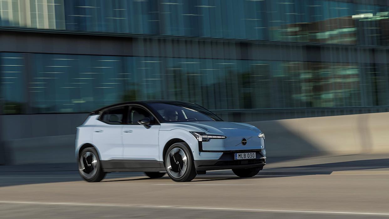 The Volvo EX30 in a pastel blue on the move, front 3/4 view