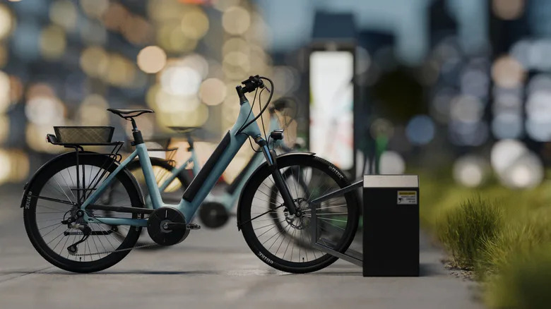 Electric bikes parked in a city at night with skyscrapers in the background.