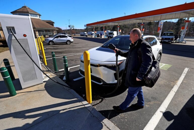 Dennis Qirollari of Newton charged his electric vehicle at the Natick EV spot on the Massachusetts Turnpike in 2024.
