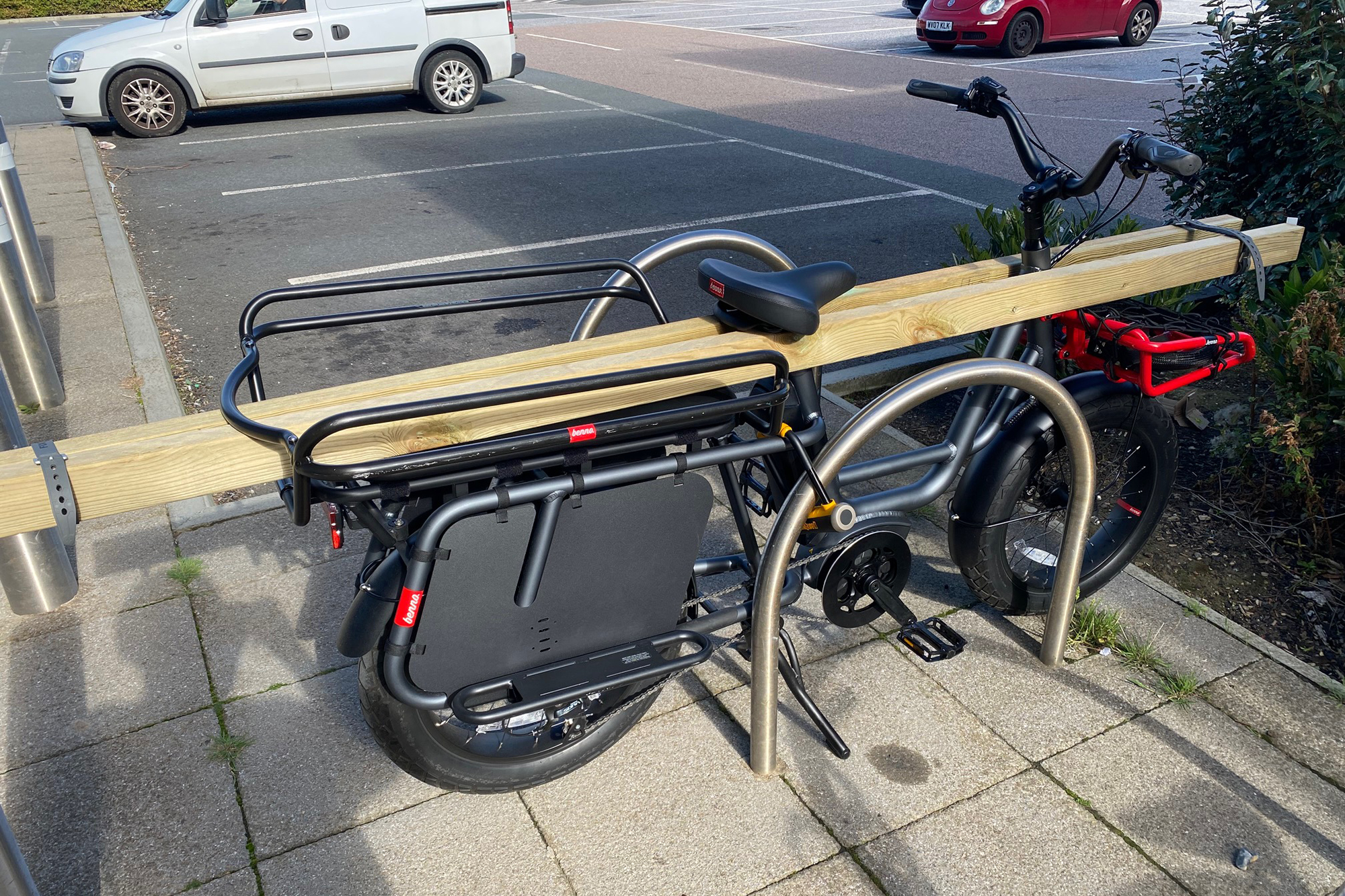 RemiDemi XL by Benno outside a popular DIY store with Long lengths of wood strapped down either side of it.