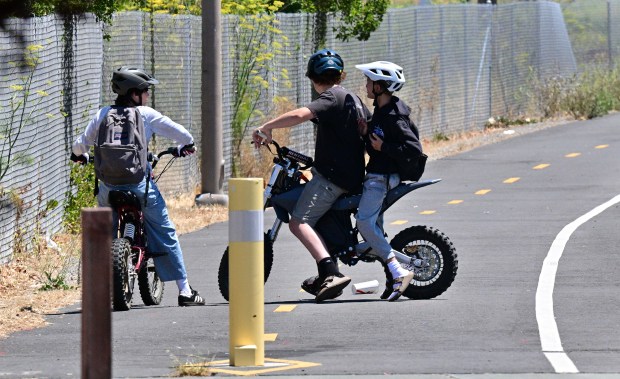 E-motorcycle riders are seen on a pedestrian/bike path in Novato, Calif. on Wednesday, July 9, 2025. (Sherry LaVars/Marin Independent Journal)