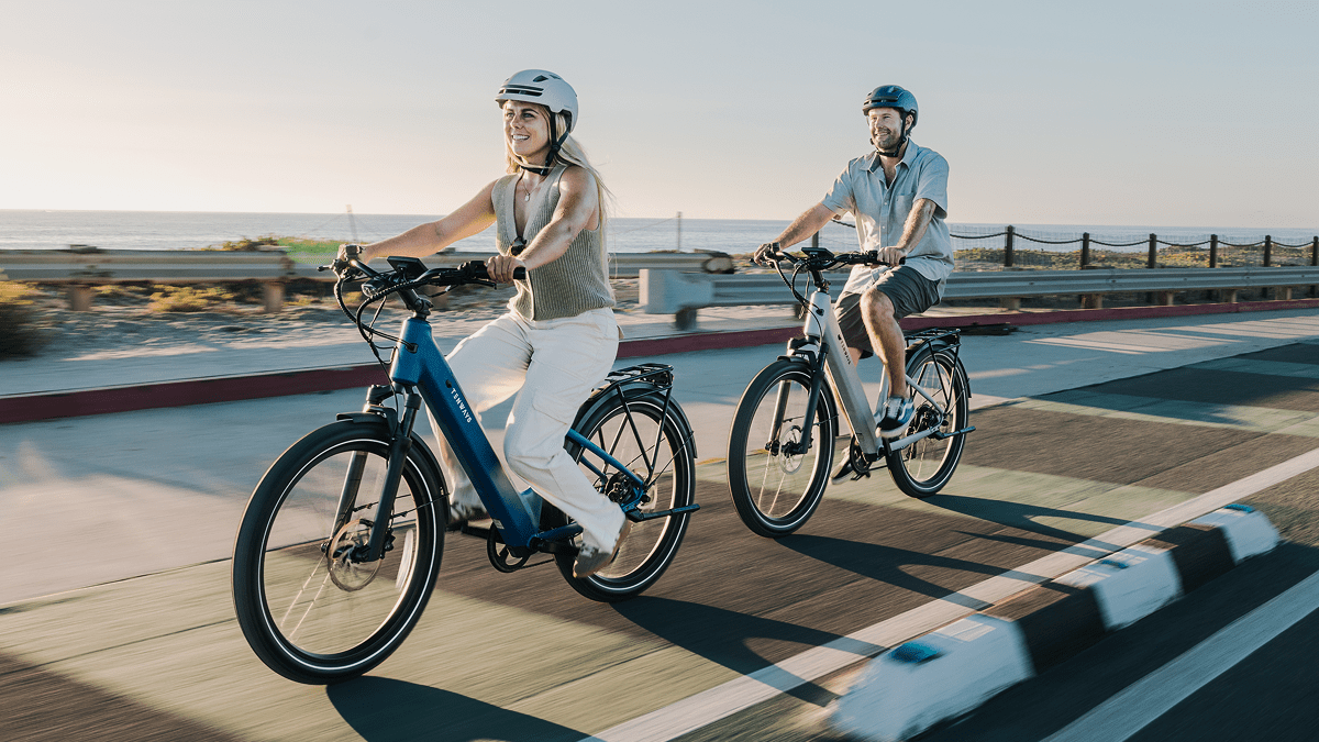 A man and woman riding bicycles on a road