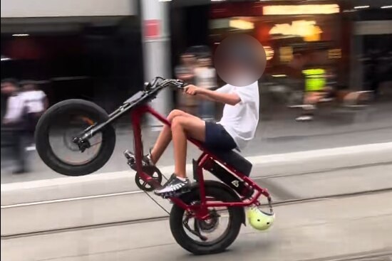 Teen doing wheelie on e-bike