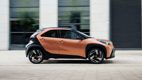 Best small hybrid cars: Toyota Aygo X Hybrid - side, orange, driving