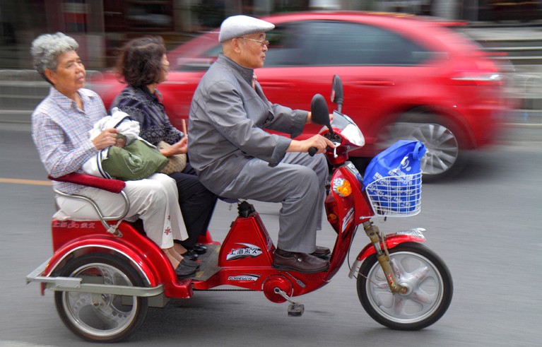 Three senior citizens zip through the streets of Beijing on a motorised tricycle.