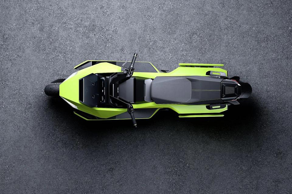 Top view of a neon green and black electric motorcycle on a textured gray surface.