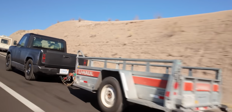 pickup truck towing a uhaul trailer on the highway