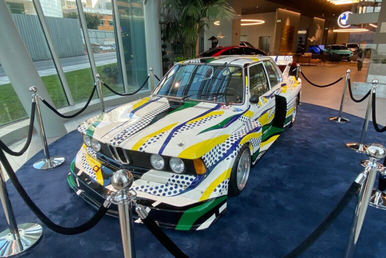 [BMW E30 Race Car] being displayed in a BMW dealership