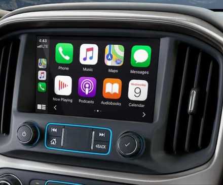 Close-up shot of the infotainment screen displaying Apple CarPlay in a GMC.