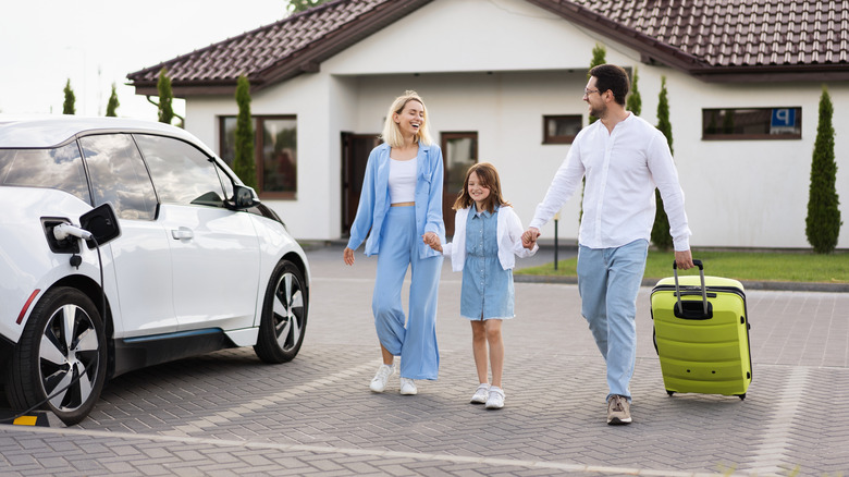 Family of three next to a charging EV