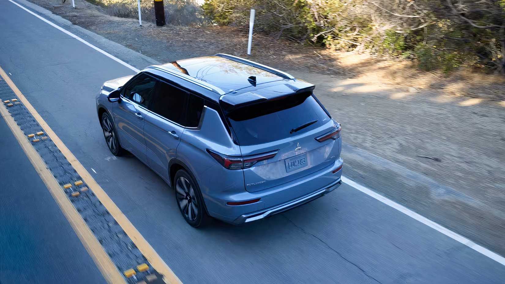 2026 Mitsubishi Outlander rear 3/4 shot driving down road