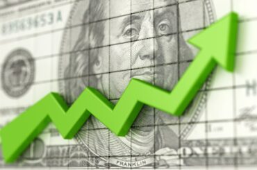 Green arrow moving upward over $100 bill.