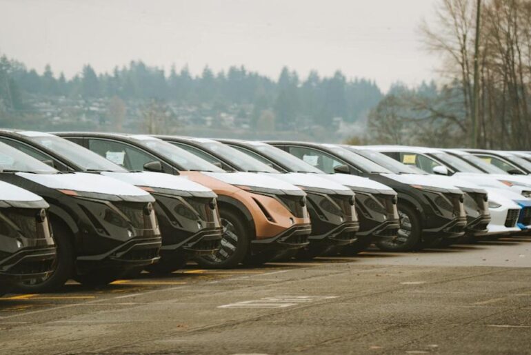 Rows of sleek electric cars parked outdoors, showcasing automotive design and innovation.