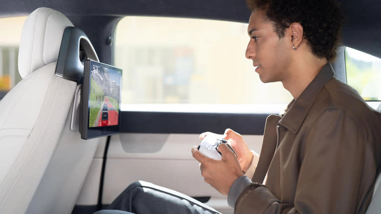 Person holding PS5 controller in Afeela car