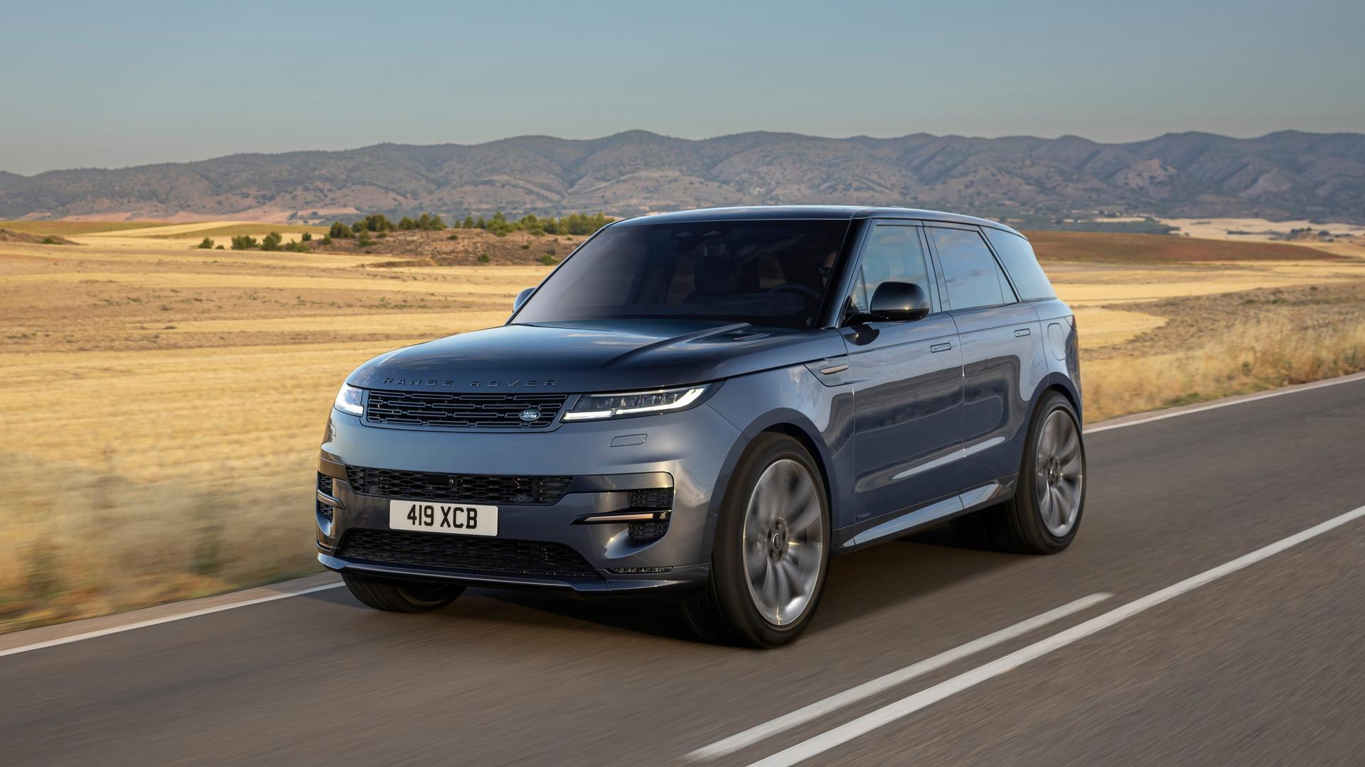 A blue Range Rover Sport driving along an empty rural road.