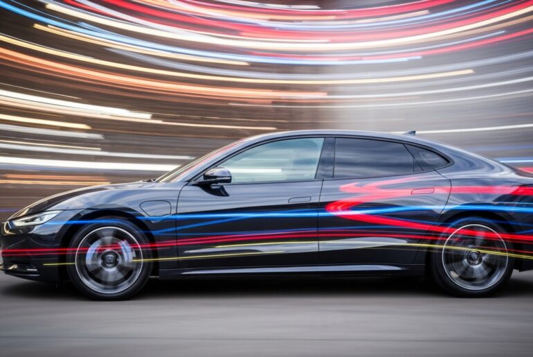 An abstract, colorful image of a sleek electric vehicle in motion, with blurred lines and shapes conveying a sense of speed and modern engineering.