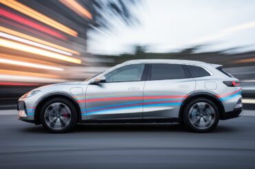 An abstract, blurred image of a Xiaomi YU7 electric SUV in motion, with streaks of vibrant colors representing the vehicle