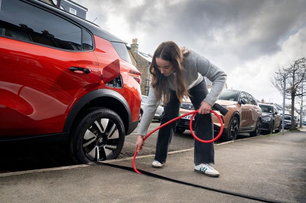 Driver charging Vauxhall electric car with a Kerbo Charge charger