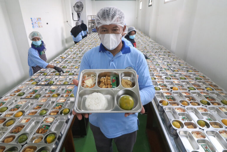 Safe plates: A staff member displays a free nutritious meal program platter on Monday during the launch of the nutritional fulfill- ment service unit (SPPG), at Al Amien Islamic Boarding School in Kediri, East Java. Equipped with proper sanitation and health standards, the unit has a cooking capacity of up to 3,400 portions per day. It was launched to provide free meals to boarding school students and pupils from several schools.