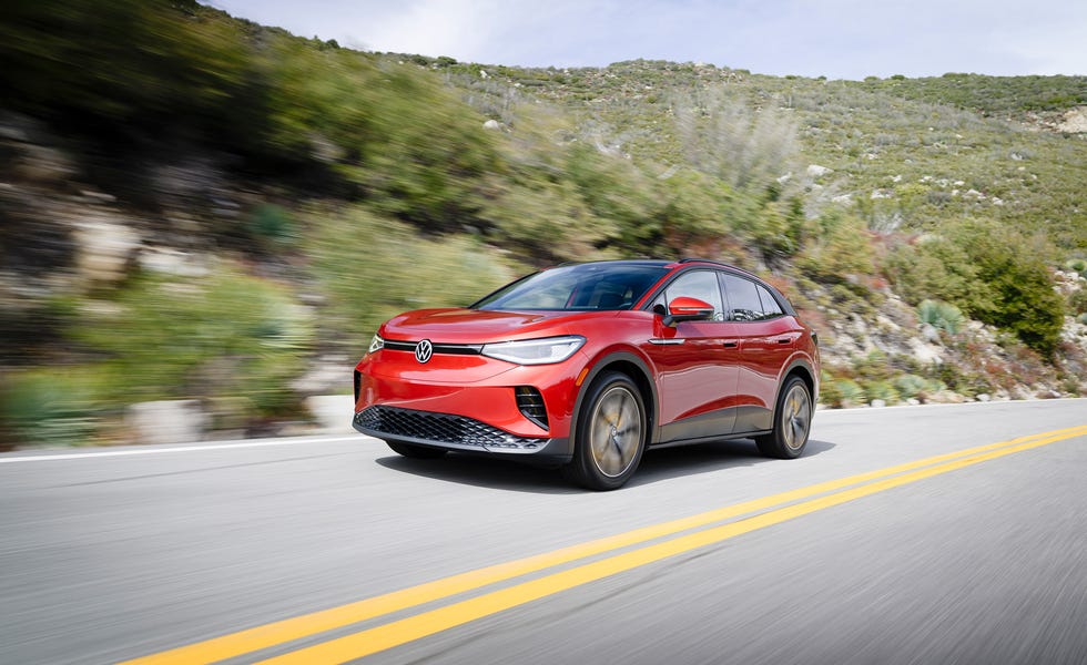 front three quarter view of a red compact suv driving on a curved mountain highway.
