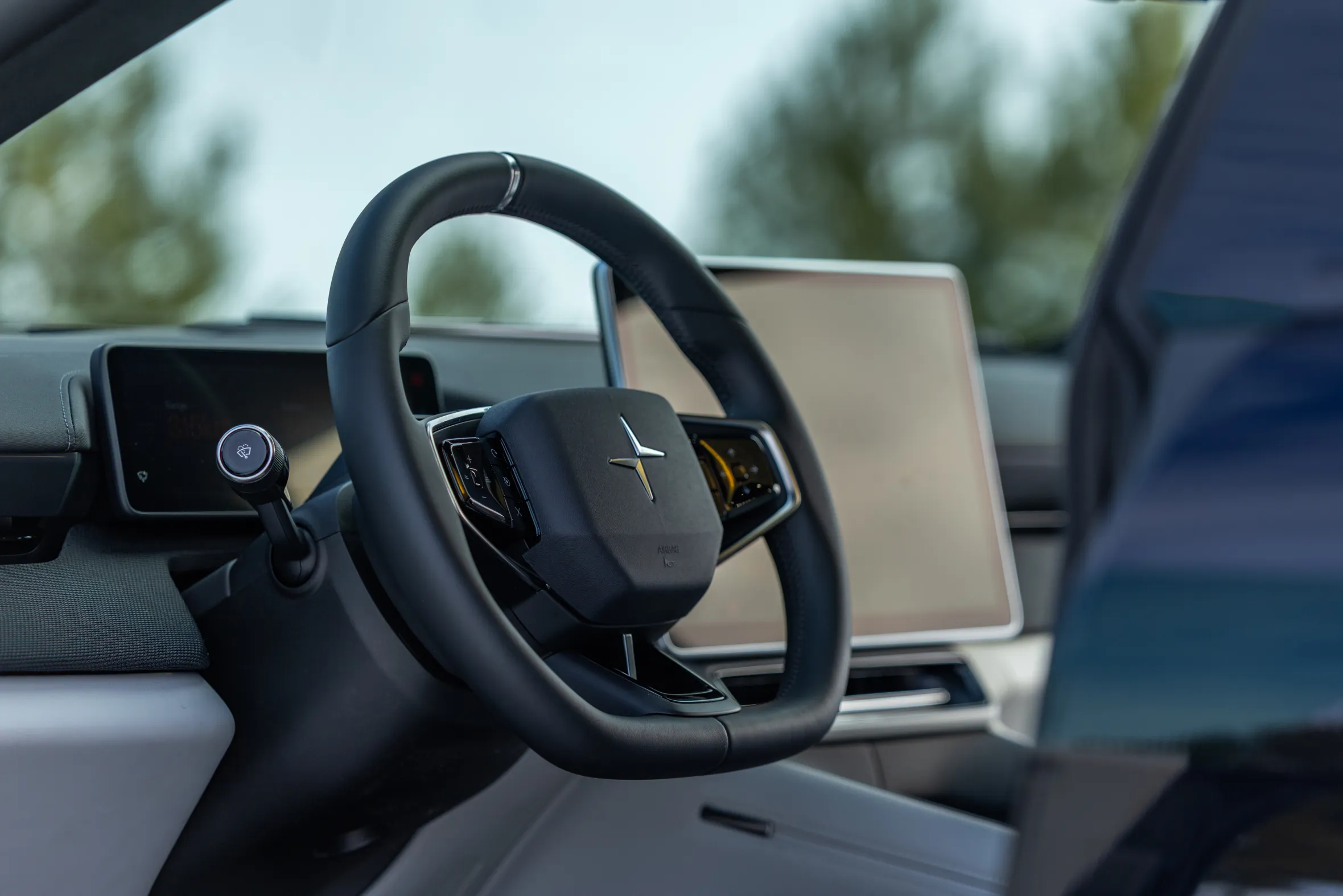 The interior of a Polestar 4 with a steering wheel and dashboard screens.
