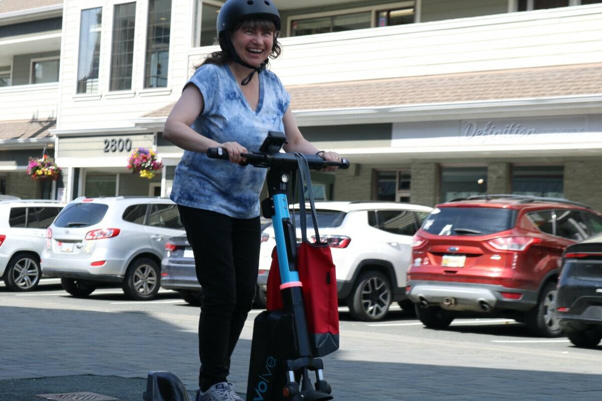 Coun. Mary Wagner flies by the crowd on a new e-scooter in Langford. (Ben Fenlon/Goldstream Gazette)