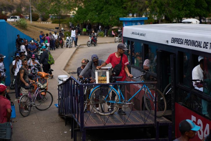 People load their bicycles onto a public bus to cross the Bay Tunnel in Havana, Wednesday, April 8. AP-Yonhap