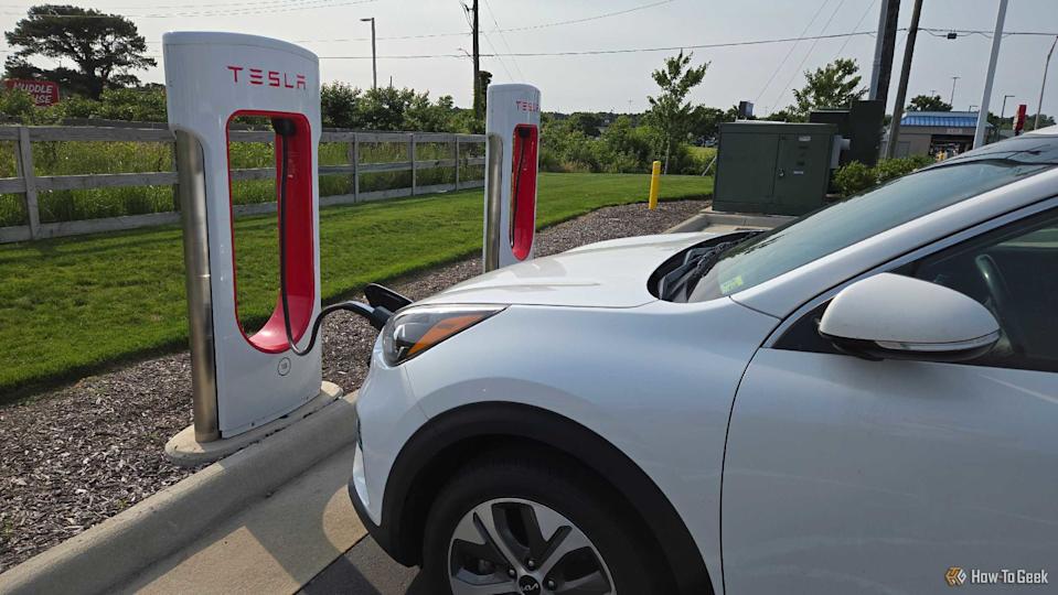 A Kia Niro EV charging at a Tesla Supercharger.