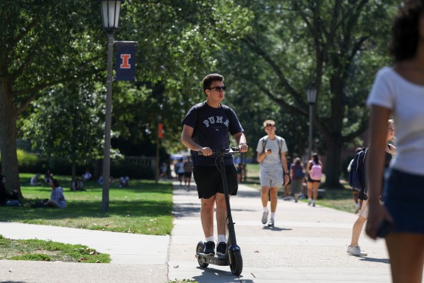 A person rides an e-scooter near the main quad on the University of Illinois campus in Urbana on Sept. 15, 2025. (Eileen T. Meslar/Chicago Tribune)