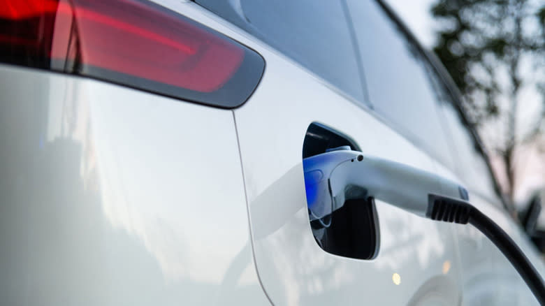 Close up of an EV charging port with a cable attached.