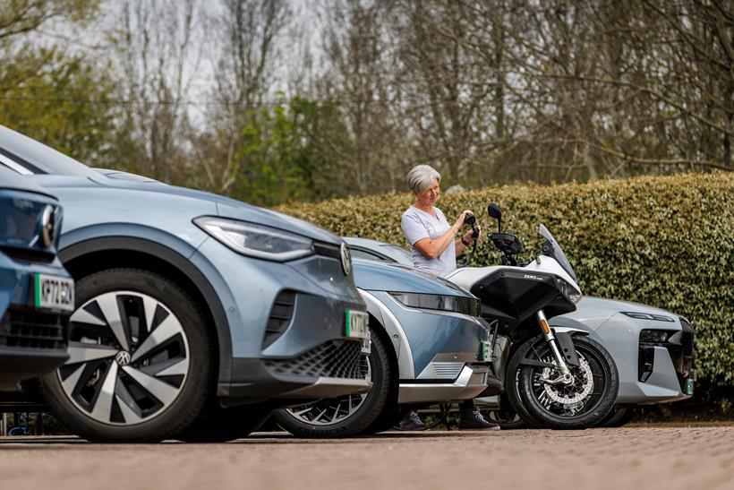 Electric motorcycle being recharged amongst electric cars