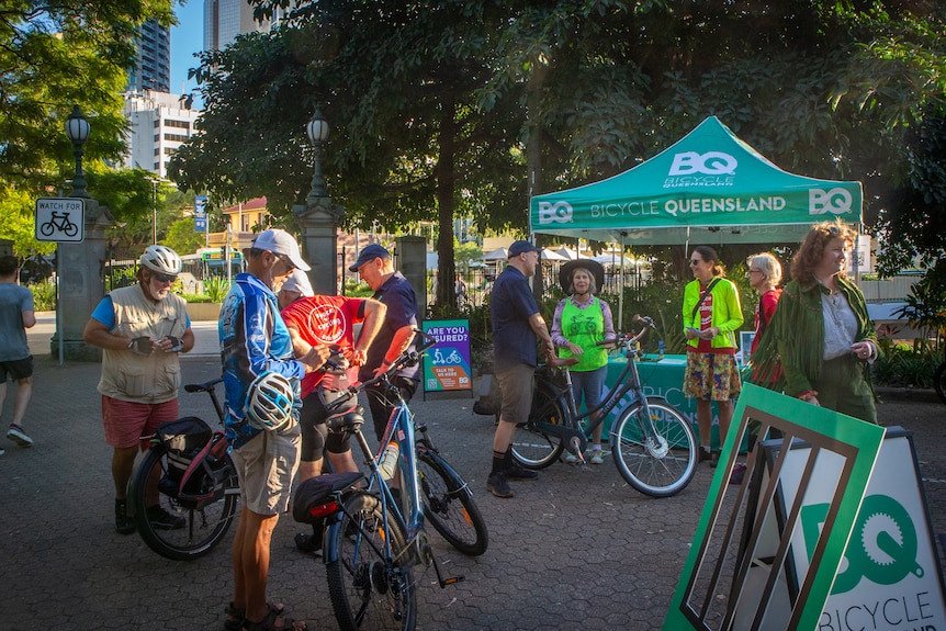 A group of people with bicycles standing around